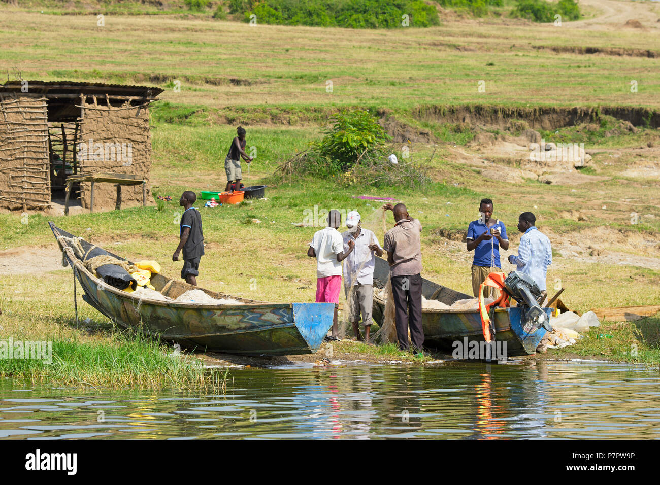 Ispezione dei pescatori, tendendo le loro reti,villaggio di pescatori sul canale Kazinga, Queen Elizabeth National Park, Uganda Foto Stock