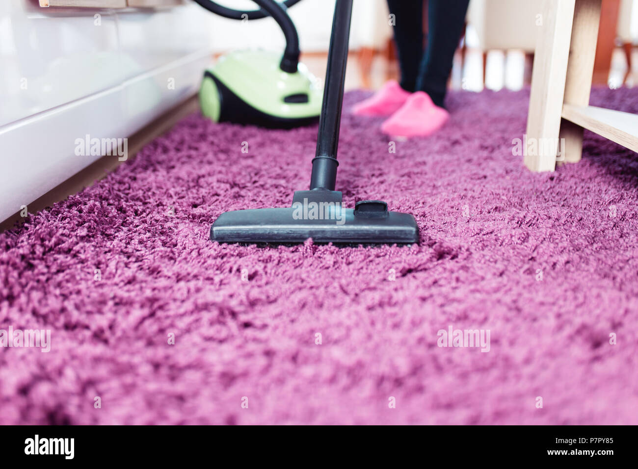 Bella giovane donna sorridente TV di pulizia con un panno in microfibra. Foto Stock