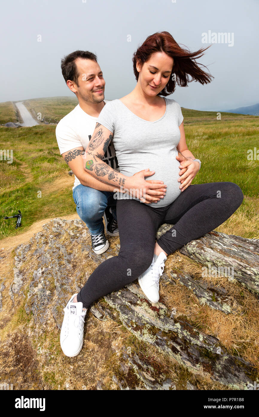 Coppia giovane in attesa di un bambino, al di fuori della montagna Foto Stock