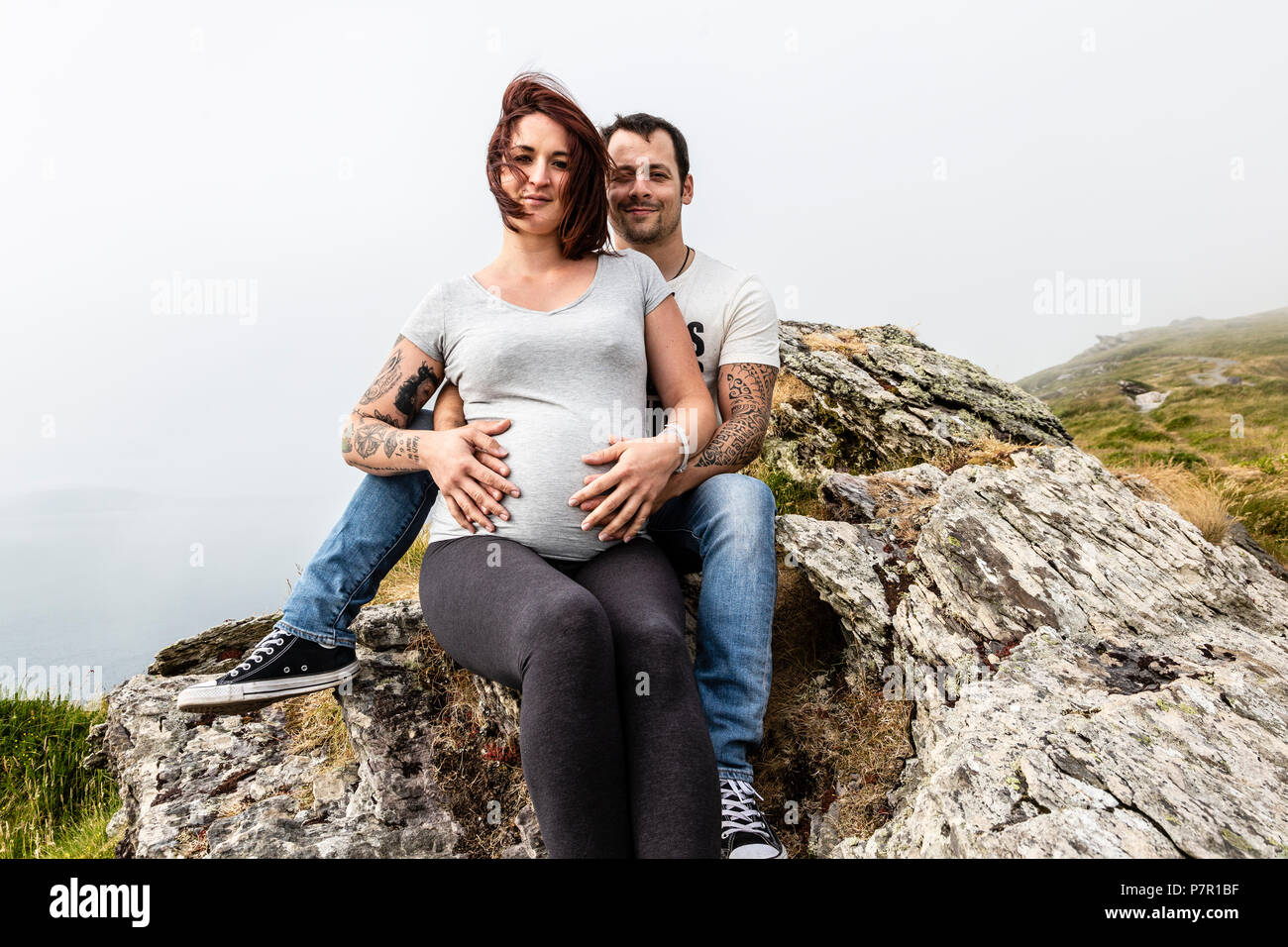 Coppia giovane in attesa di un bambino, al di fuori della montagna Foto Stock