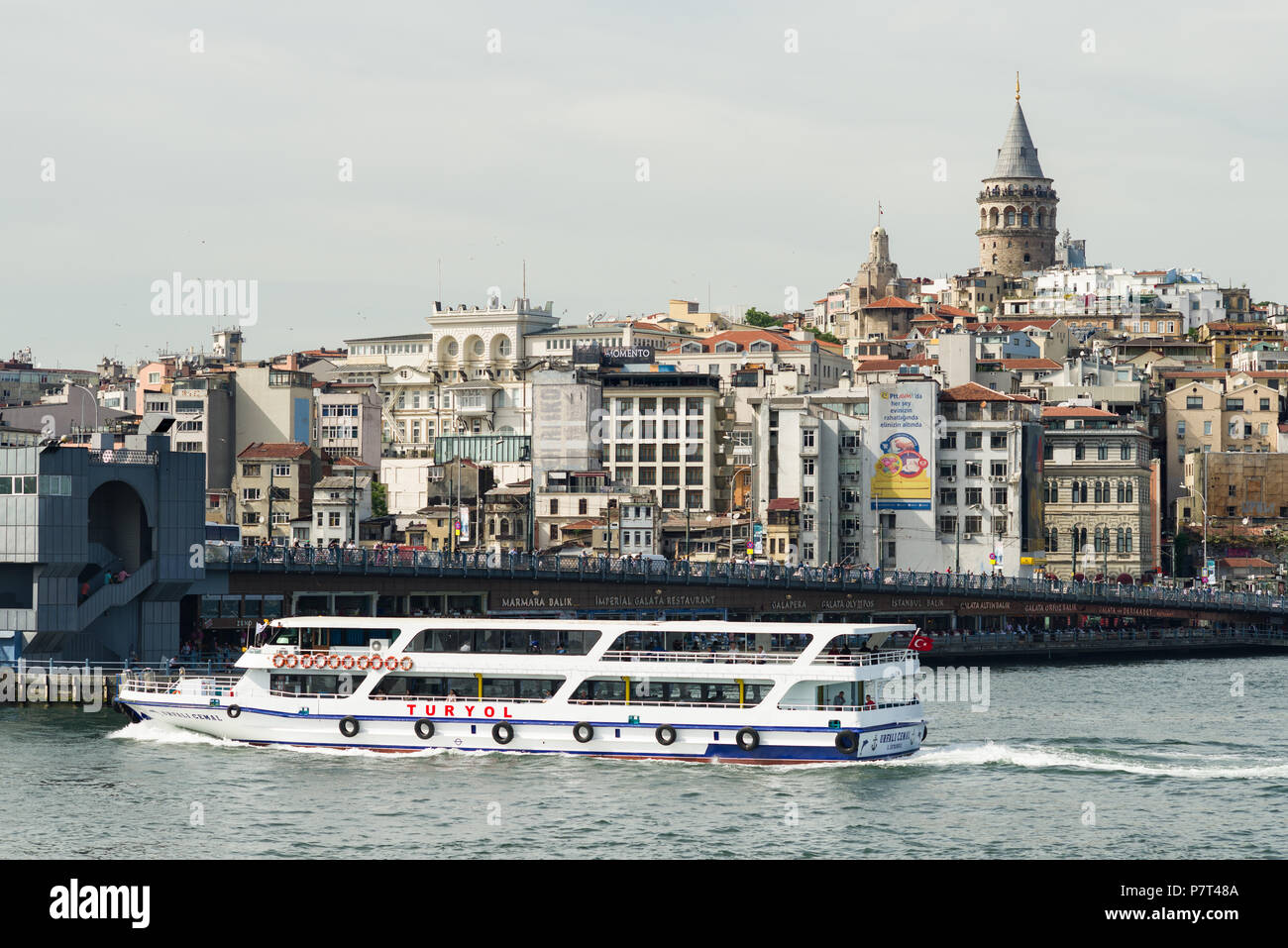 Un traghetto Turyol dirigendosi verso il Ponte di Galata con Torre Galata e Karaköy in background, Istanbul, Turchia Foto Stock