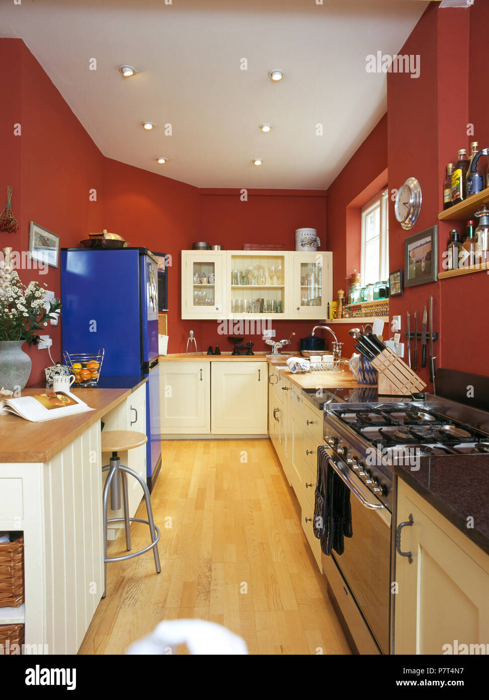 In acciaio inox forno gamma in rosso cucina galley con blu brillante frigorifero con congelatore Foto Stock