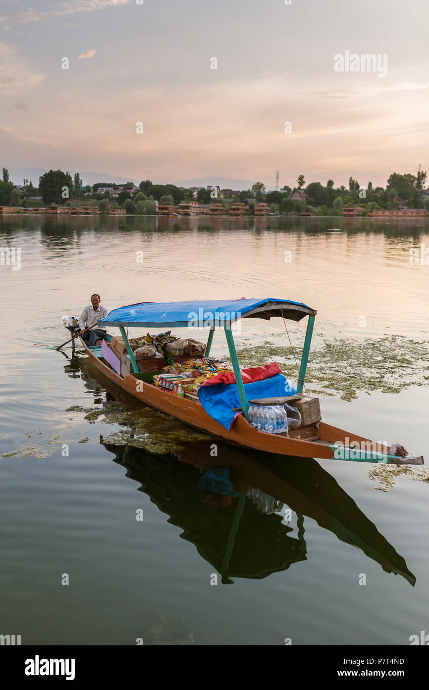 Srinagar, India - 13 Giugno 2017: Non identificato uomo kashmir vendita di negozio di generi alimentari per i turisti dalla sua barca sul lago Nagin a Srinagar. Foto Stock