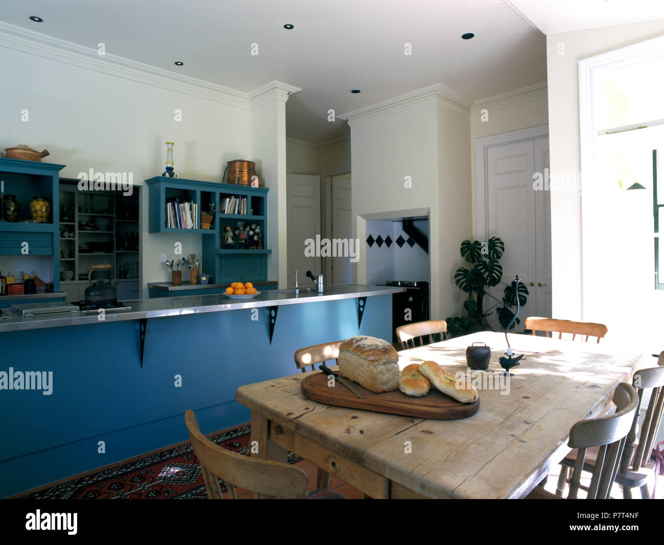 Pane sfregata sulla tavola di pino in cucina con blu unità centrale Foto Stock