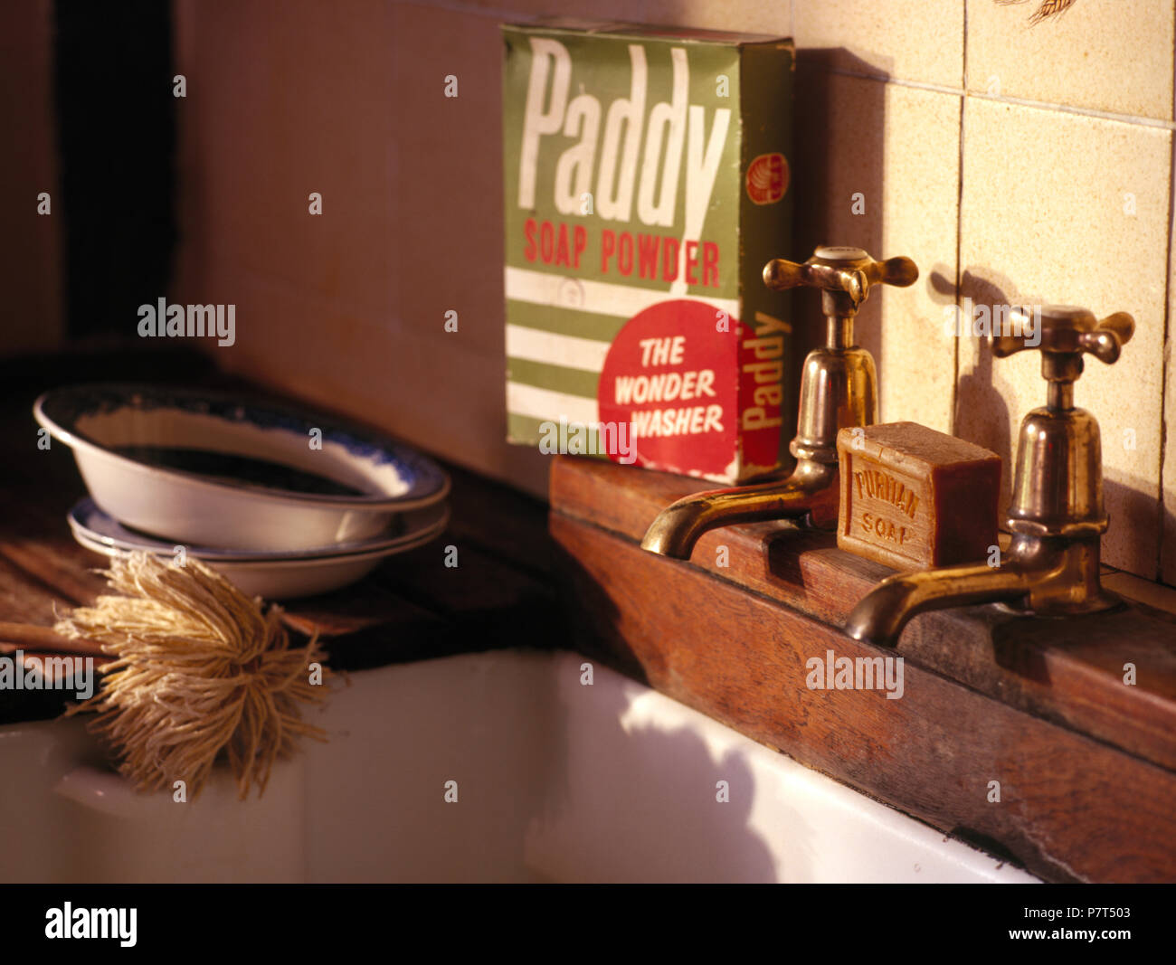 Casella di vintage polvere di sapone accanto a trenta lavandino con rubinetti in ottone Foto Stock