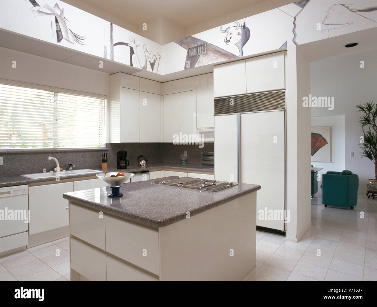 Piano di cottura in unità di isola in bianca e moderna cucina con frigorifero grande Foto Stock