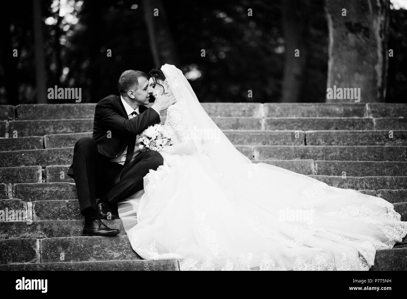 Sposi seduti nel parco sulla soleggiata estate giorno di nozze. Foto in bianco e nero. Foto Stock