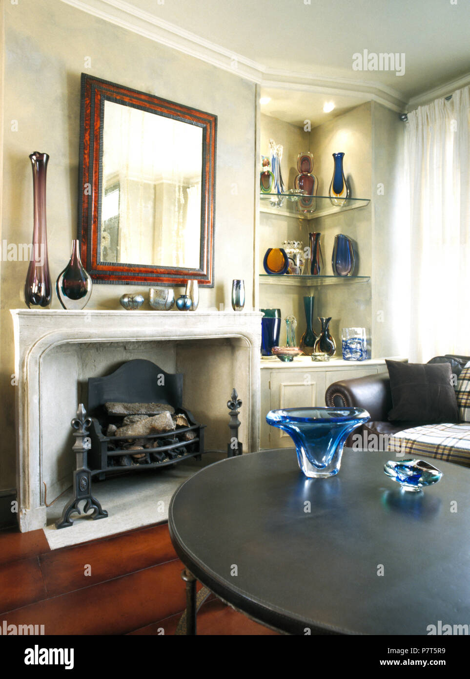Blu vaso in vetro nero sul tavolino di fronte al caminetto a townhouse soggiorno Foto Stock