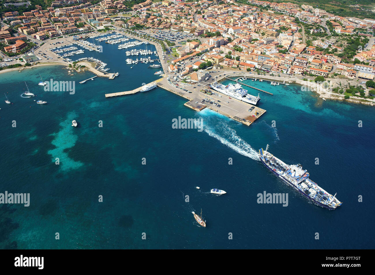 VISTA AEREA. Città di Palau con il suo porto turistico, traghetto in partenza per l'isola di Maddalena. Provincia di Sassari, Sardegna, Italia. Foto Stock