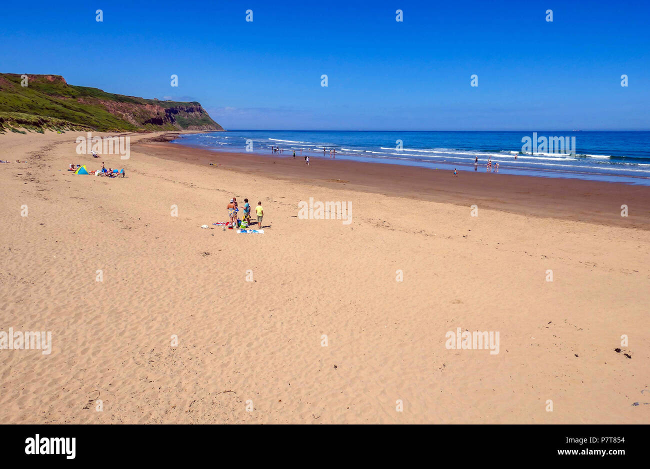 Grande spiaggia di sabbia sul blu caldo giorno d'estate come cittadina balneare di Skinningrove, North Yorkshire Foto Stock