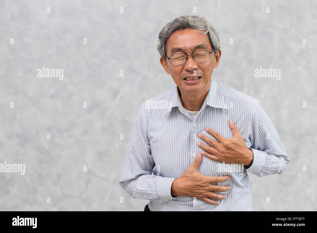 Il vecchio uomo di vernice da un attacco di cuore il coperchio a mano il petto con spazio di copia Foto Stock
