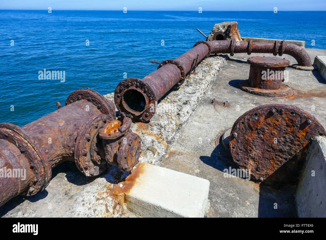 Vecchi tubi arrugginiti e blu caldo giorno d'estate come cittadina balneare di Skinningrove, North Yorkshire Foto Stock
