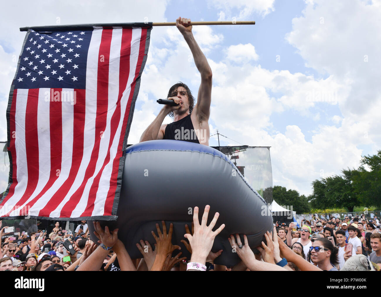 Jake Taylor di In sente Wake canta mentre sventolare la bandiera americana e di essere portato sopra la folla in una barca gonfiabile durante il Van's Warped Tour presso l'AT&T Center sabato. Credito: Robin Jerstad/Alamy Live News Foto Stock