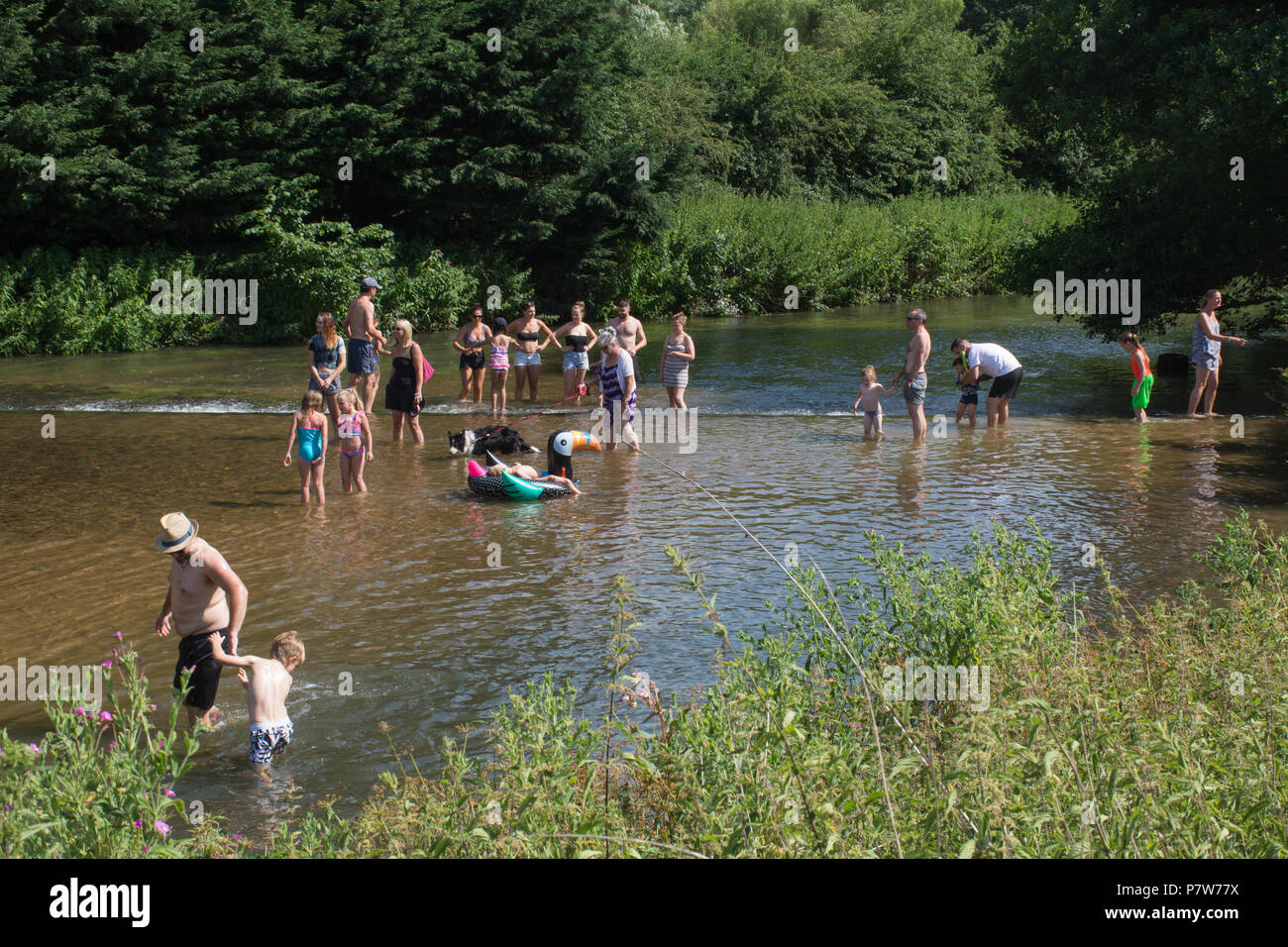 Tilford, Surrey, Regno Unito. 8 luglio 2018. Mentre l'ondata di caldo continua, la gente si divertivano al sole in una bella domenica pomeriggio nel grazioso villaggio di Tilford. Molti si stavano rinfrescando nel fiume o prendendo il sole. Foto Stock