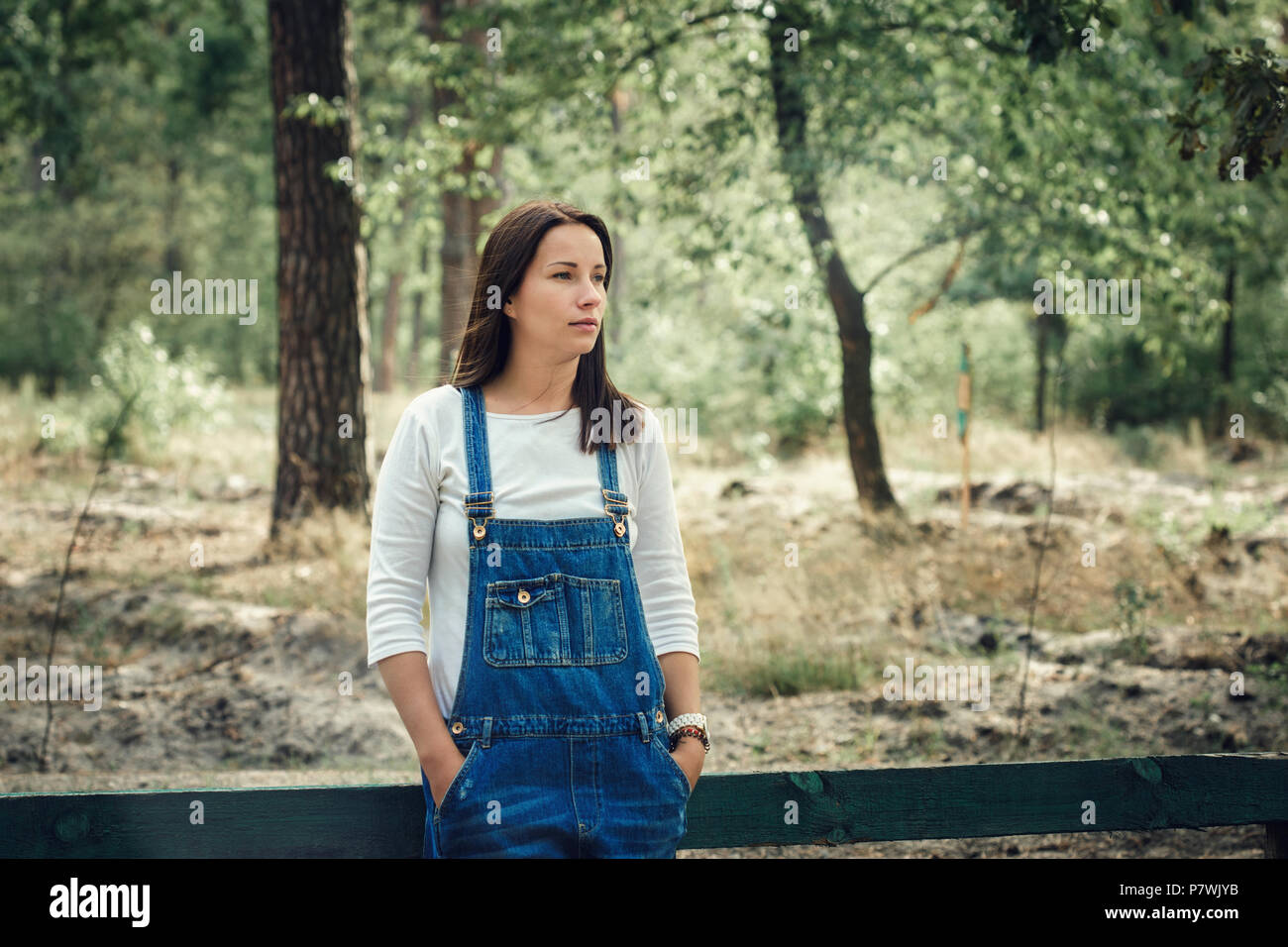 Bella giovane donna in tuta in jeans all'esterno. Foto Stock