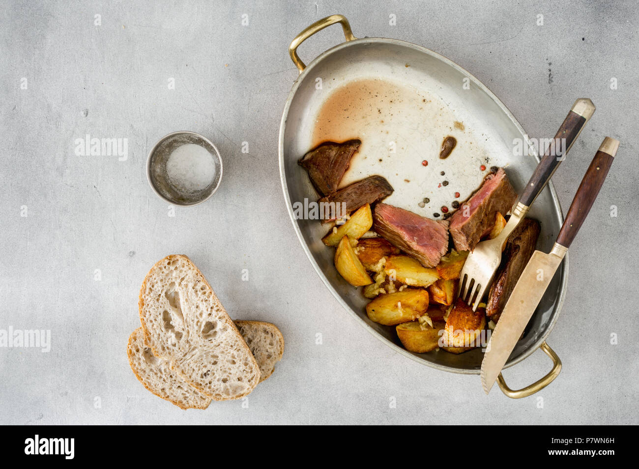 Fette di carne di manzo con patate in salsa di aglio in padella, vista dall'alto. Cibo fatto in casa concept Foto Stock