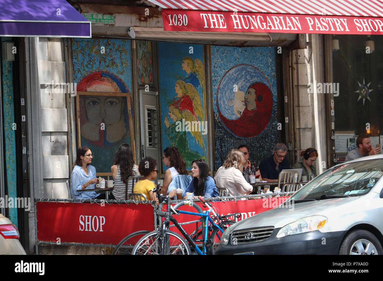 Molte persone sedute tavoli all aperto in un cafè sul marciapiede,godendo di caffè e pasticceria presso la pasticceria ungherese Shop nella Upper West Side di New York City Foto Stock