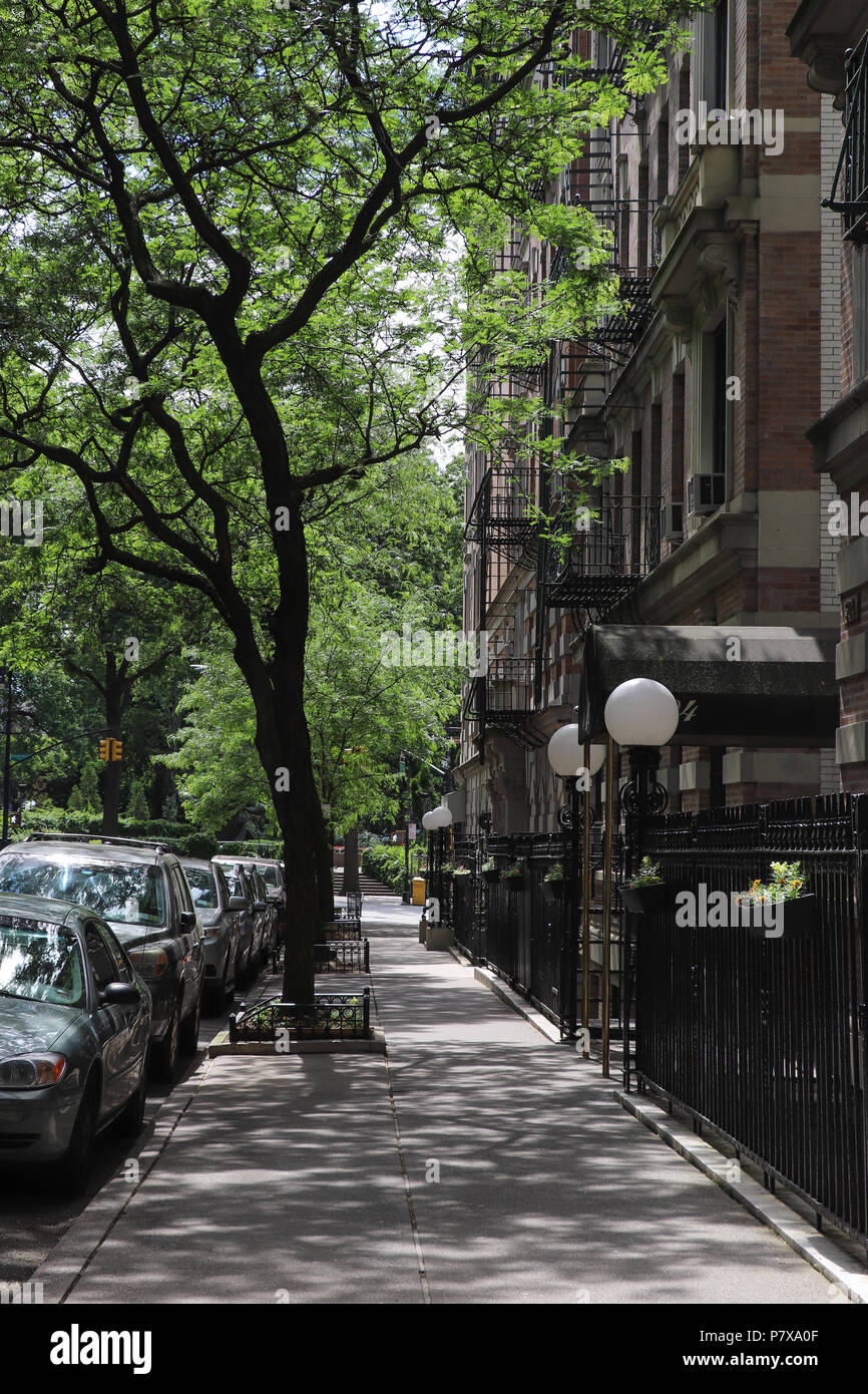 Guardando verso il basso W. 111Street il marciapiede in sulla Upper West Side di New York City, il mattone rosso pre-guerra appartamento edifici, alberi di alto fusto, piacevole. Foto Stock