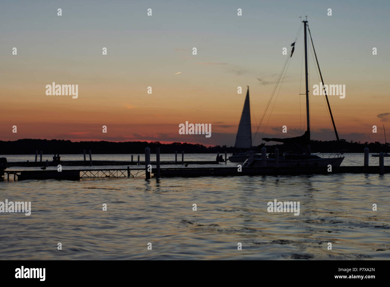 Barche a vela al tramonto dal dock. Foto Stock