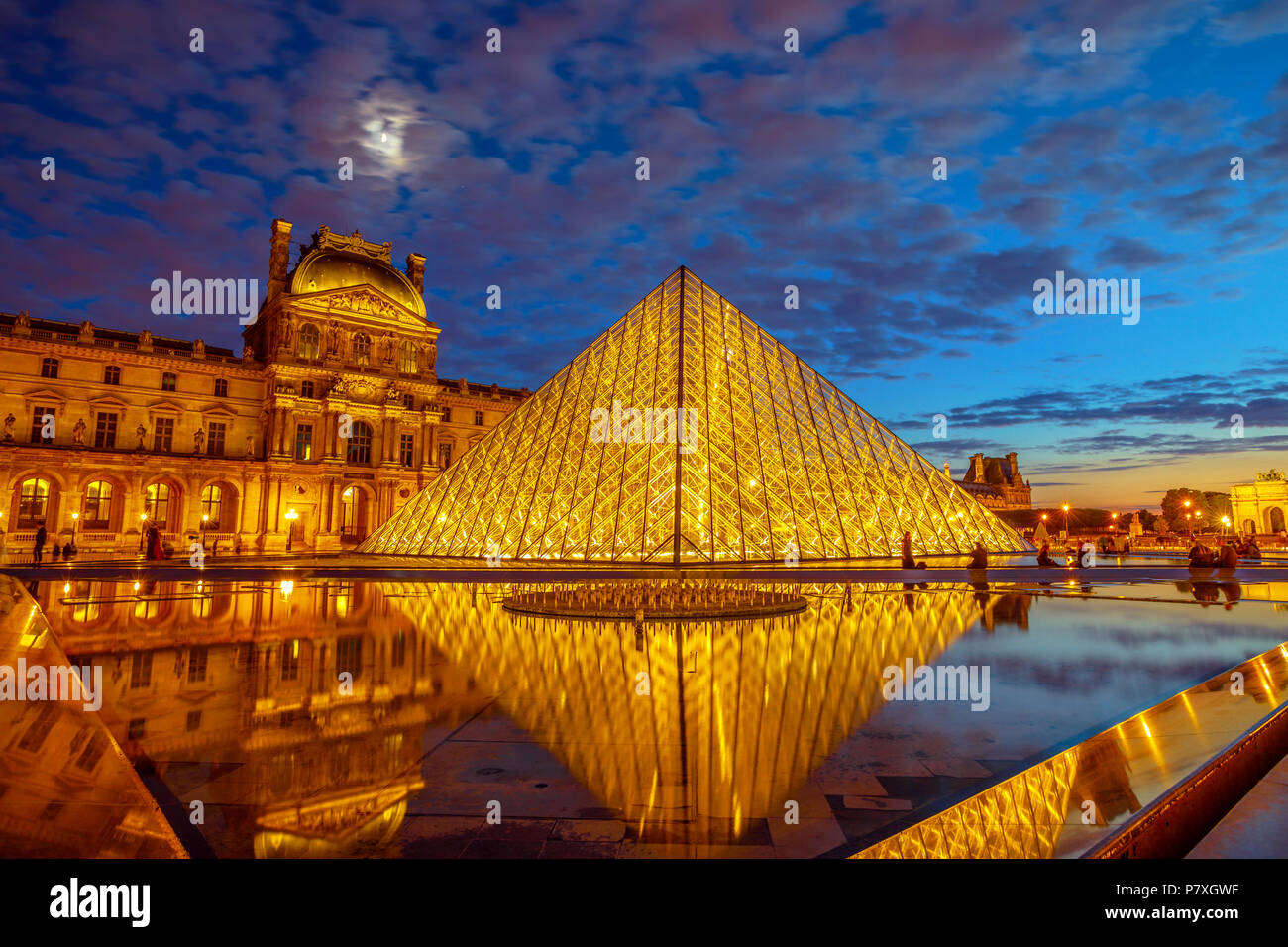 Parigi, Francia - luglio 1, 2017: twilight riflessioni intorno al museo del Louvre piramide in vetro. Palazzo del Louvre nel cortile. Galleria foto hosting landmark Mona Lisa dipinto da Leonardo Da Vinci. Foto Stock
