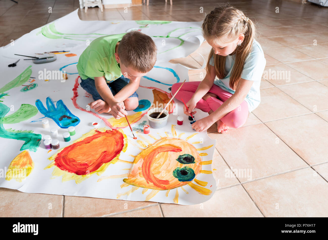 Pittura per bambini insieme su un grande pezzo di carta Foto Stock