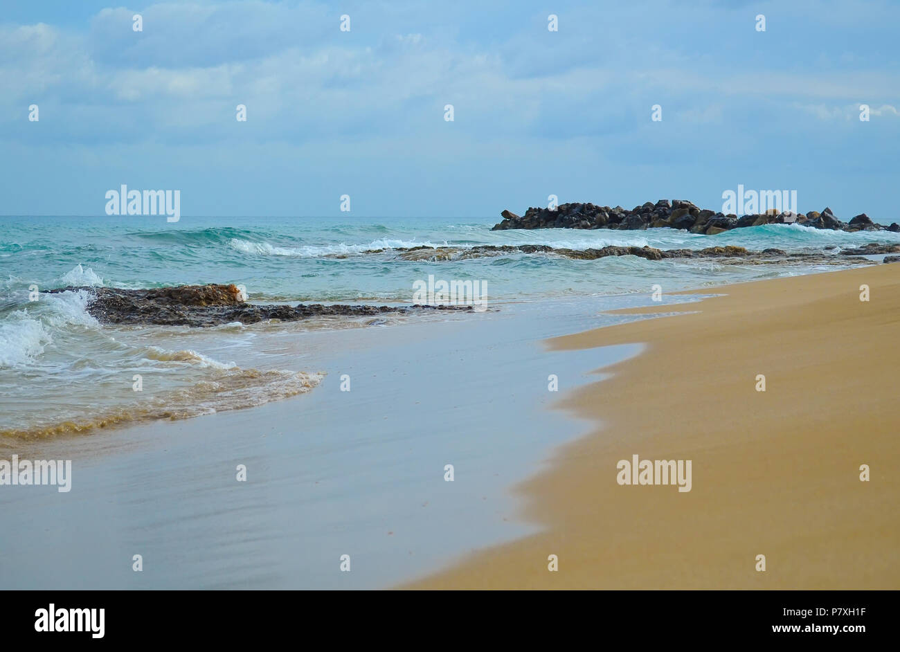Scogliera rocciosa su di una spiaggia di sabbia prima della tempesta Foto Stock