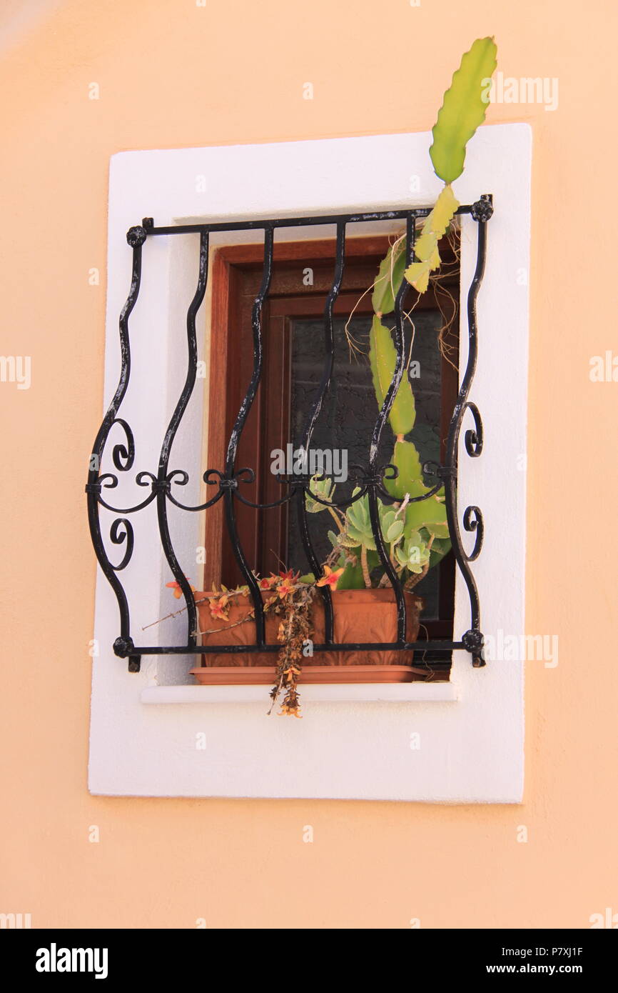 Finestra residenziale incorniciato da ferro battuto grill sulla Syros Island, a sud del Mar Egeo, Grecia, Peter Grant Foto Stock