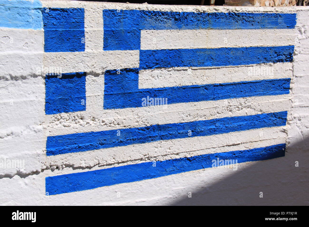 Nazionale Greco di bandiera dipinta su un muro dalla Chiesa Anastasi, Ano Syros, Syros Island, a sud del Mar Egeo, Grecia, Peter Grant Foto Stock