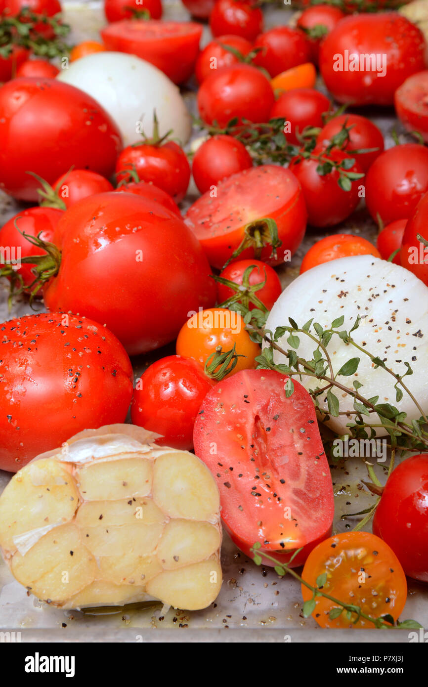 Teglia di pomodori arrostiti, aglio, erbe e olio d'oliva Foto Stock