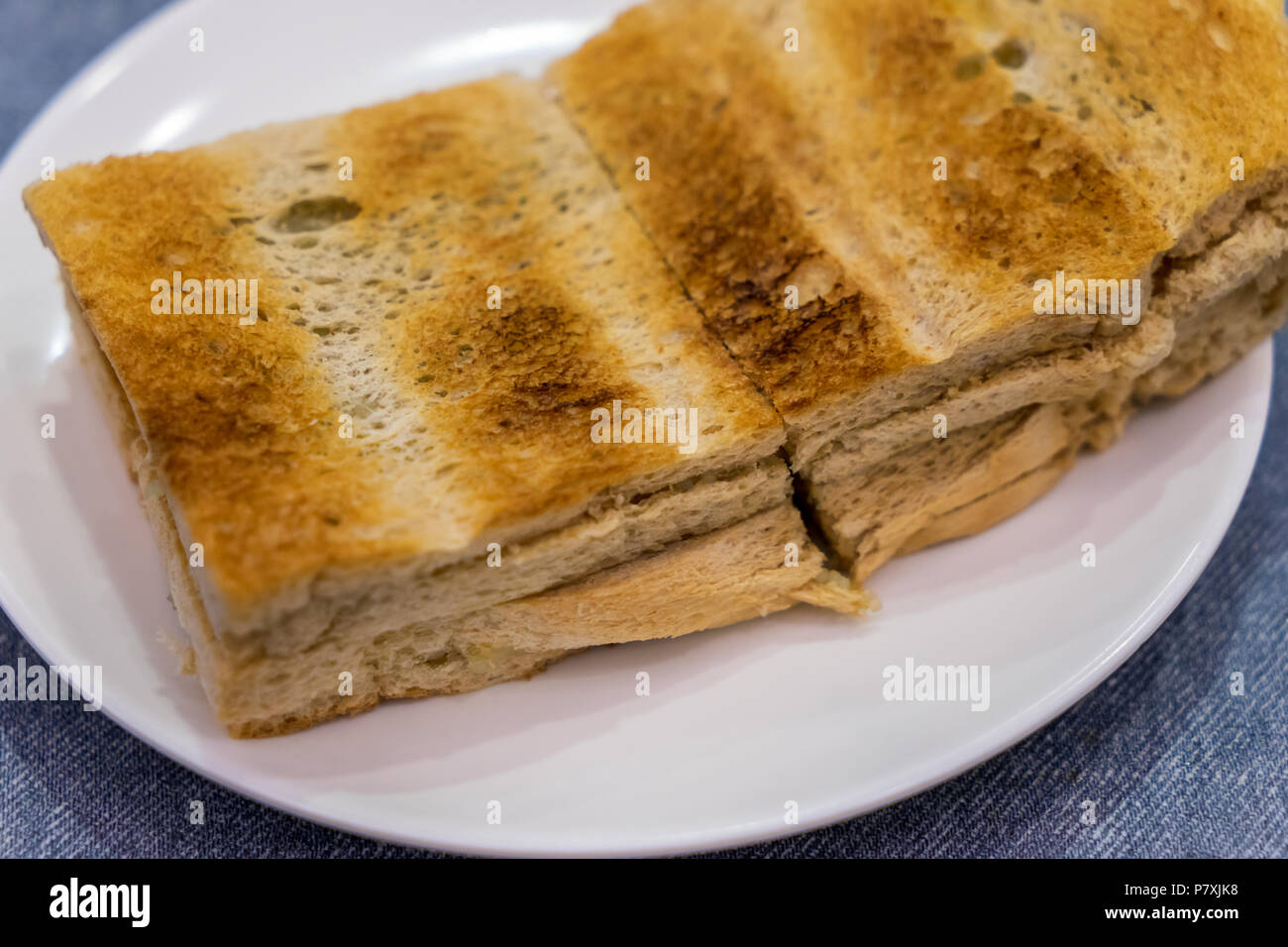 Tradizionale colazione Singapore chiamato Kaya toast, pane di cocco con marmellata e burro, il fuoco selettivo tecnica Foto Stock