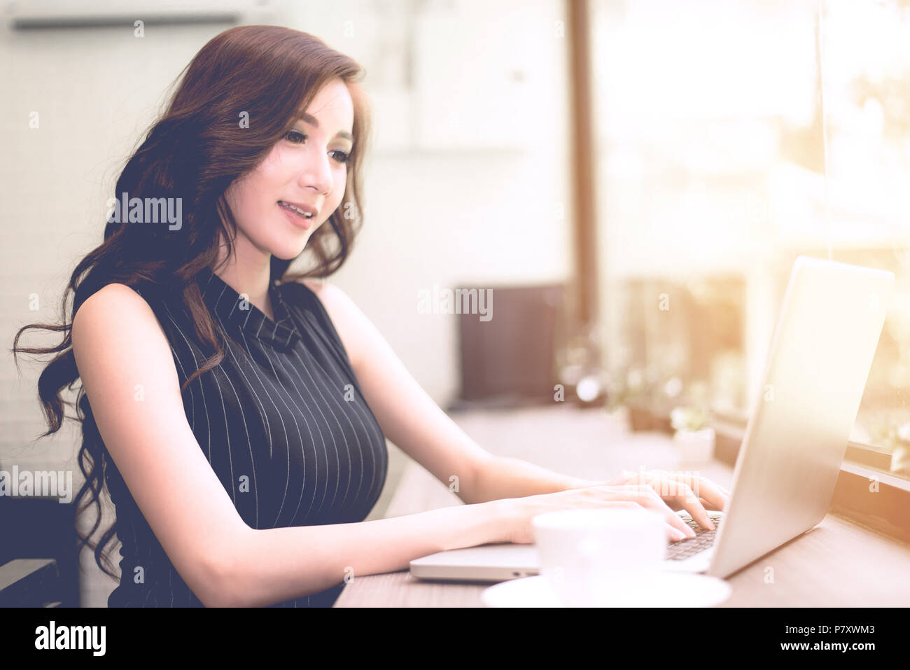 Imprenditrice utilizzando computer portatile presso la caffetteria di fronte a specchio, azienda di lavorare e rilassarsi concetto, morbido e dividere la lavorazione trasversale a tono retrò vi Foto Stock