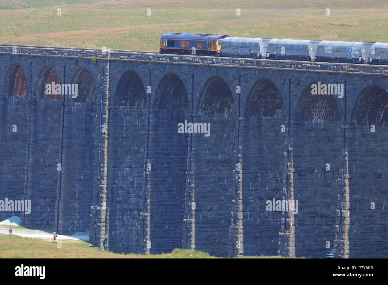 Un grande British Railway treno merci attraversa il possente e impressionante progettato in stile vittoriano viadotto Ribblehead ponte ferroviario nel Yorkshire Dales. Foto Stock