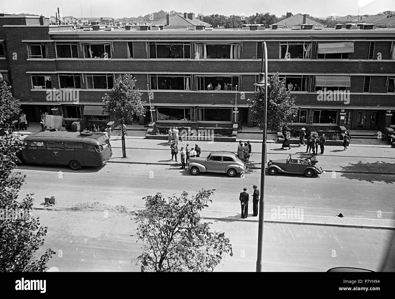 . Huizinga collectie V2 inslag - NIOD - 216554. Nederlands: Foto uit de collectie Huizinga van het NIOD. Duitse militairen en inwoners staan voor een beschadigd appartementencomplex na een V2-inslag Menno Huizinga era onderdeel van de Ondergedoken fotocamera en maakte illegaal foto tijdens de bezetting. Dit deed hij hoofdzakelijk in zijn woonplaats Den Haag (L'Aia). Data sconosciuta 37 BC856 HUI-1255 Foto Stock