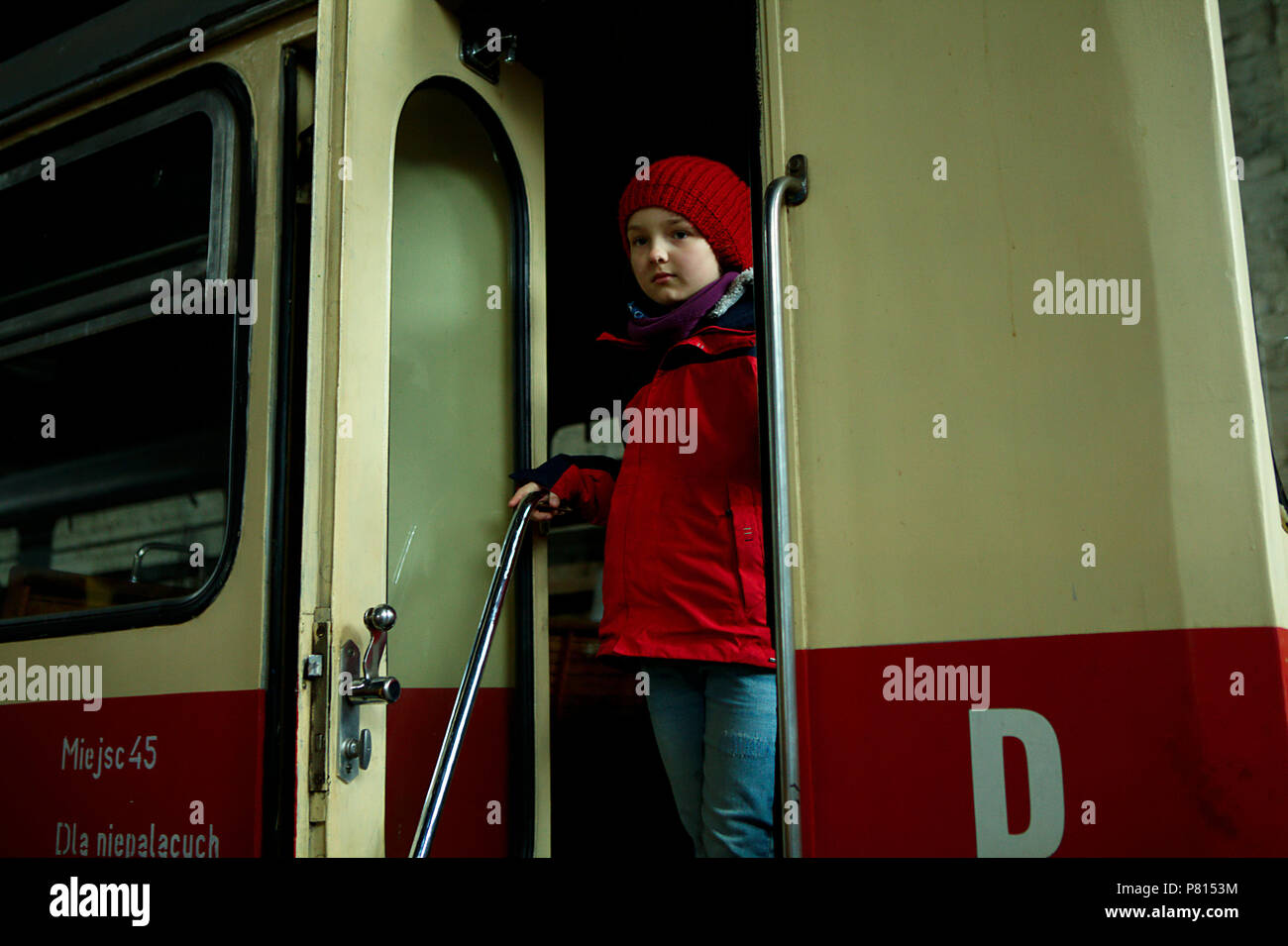 Ragazza nel cappuccio rosso alle porte della vecchia stazione Foto Stock