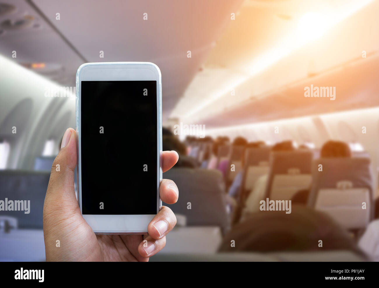 L'uomo usa il tuo telefono cellulare in aereo sfondo sfocato - mockup  modello - luce solare per effetto del filtro Foto stock - Alamy