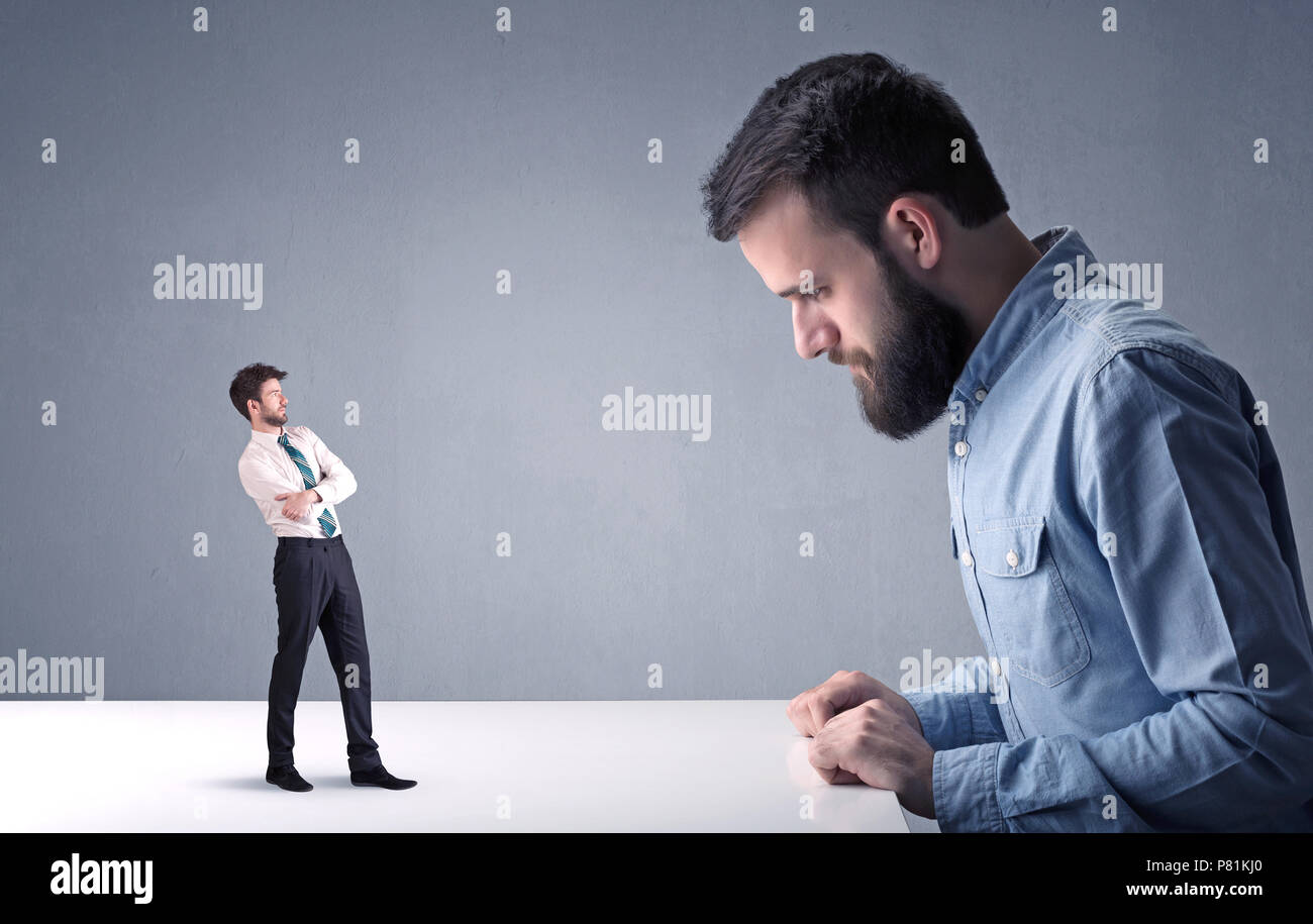 Giovane imprenditore professionale essendo arrabbiato con un altro imprenditore in miniatura Foto Stock