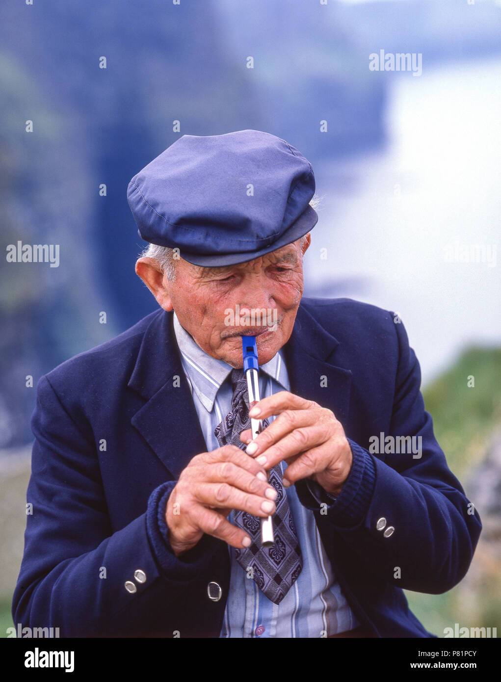 Uomo locale giocando Irish whistle (feadóg stáin), nella contea di Cork, Repubblica di Irlanda Foto Stock