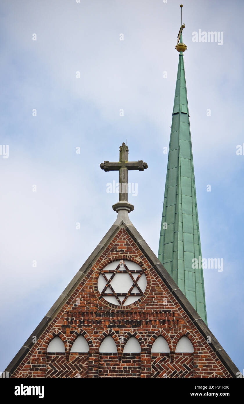 Timpano della chiesa con una croce cristiana su una stella di Davide con strette slanciata cuspide in background Foto Stock