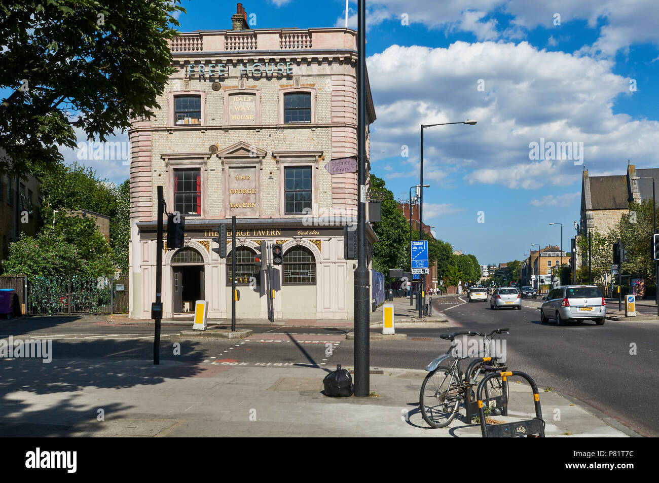 La storica Taverna George pub sulla strada commerciale, Stepney, East London UK, con Jubilee Street in primo piano Foto Stock