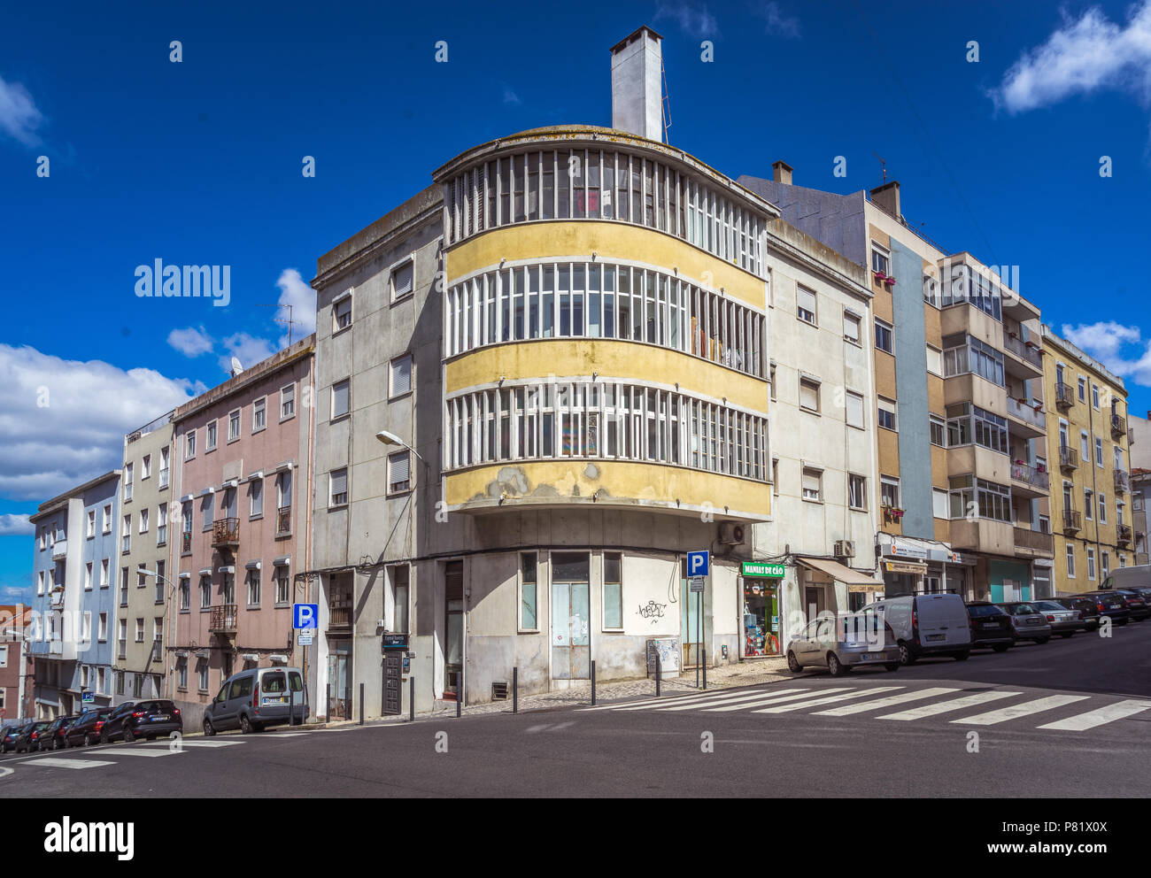 EDIFICIO MODERNISTA AD ANGOLO, balconi curvi, facciata gialla consumata, Campo de Ourique, Lisbona, Portogallo Foto Stock