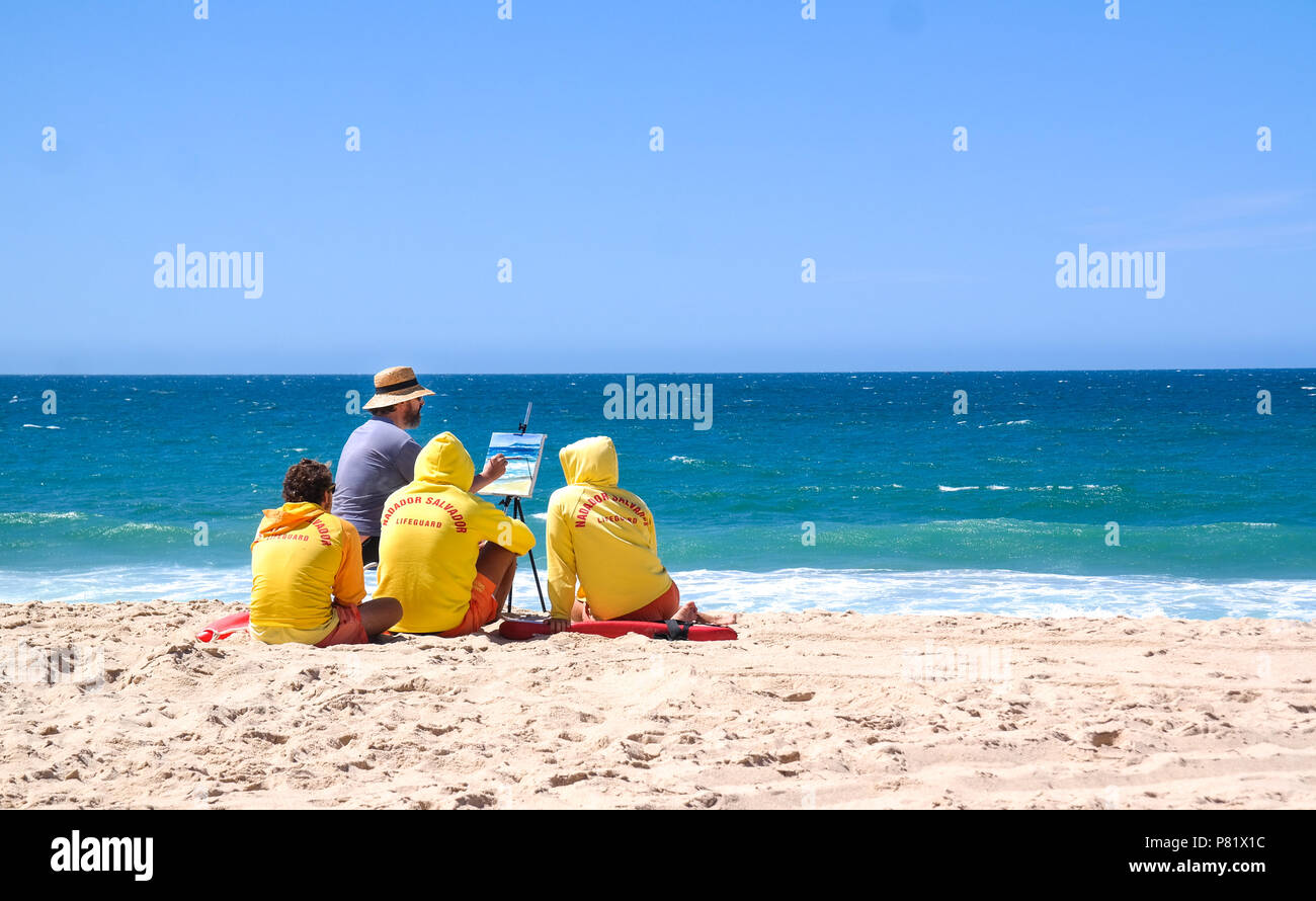 Pittore con guardie della vita in spiaggia, Portogallo Foto Stock