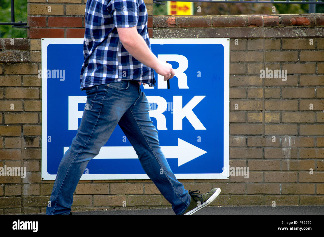 Clacton-on-Sea, Essex, Inghilterra. Regno Unito-21 maggio 2018- un uomo a piedi passato un segno a mostrargli la via per il parco auto, REGNO UNITO Foto Stock