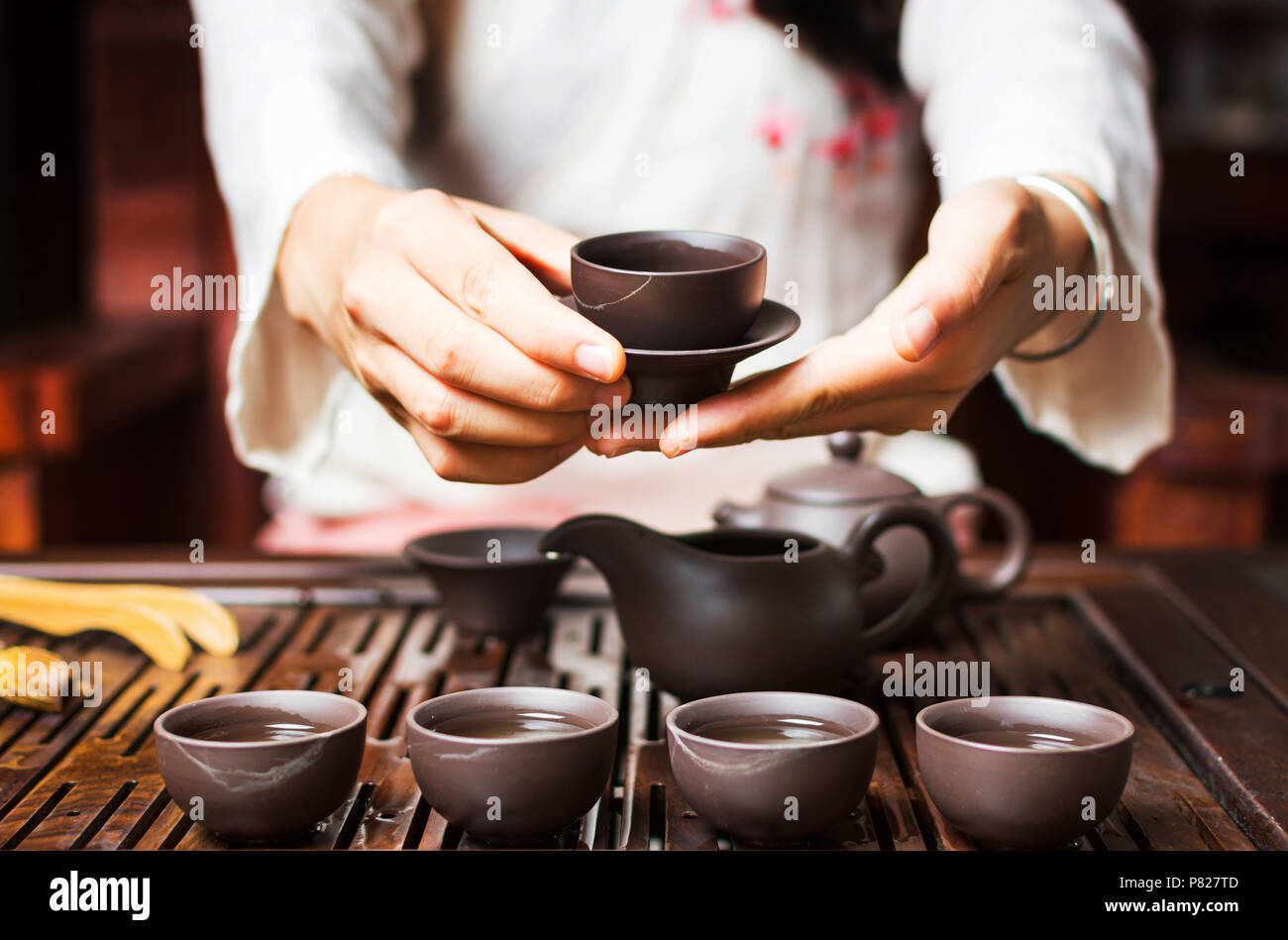 Donna che serve tè cinese in una tradizionale cerimonia del tè Foto Stock