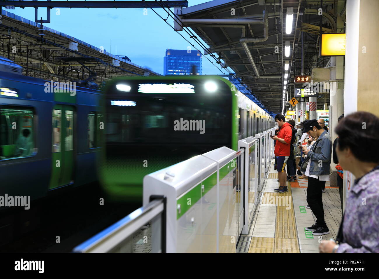 Treno in arrivo quando le persone in attesa di trasporto, IKEBUKURO TOKYO Giappone. Foto Stock