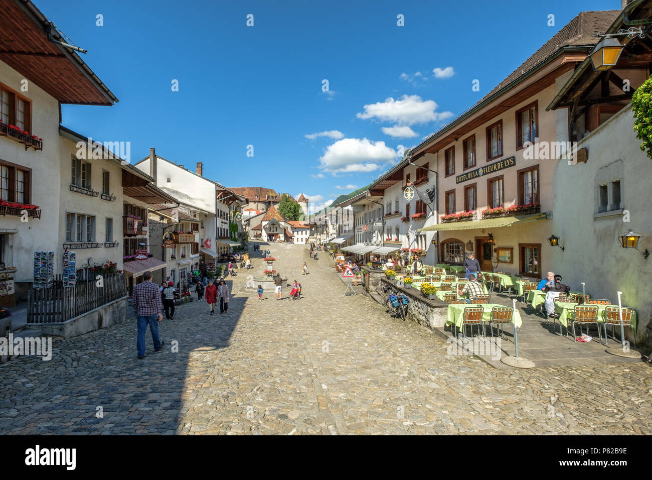 Rue de Bourg, la strada medievale fino al Gruyeres Casltle. Ristoranti e felici le persone. Foto Stock