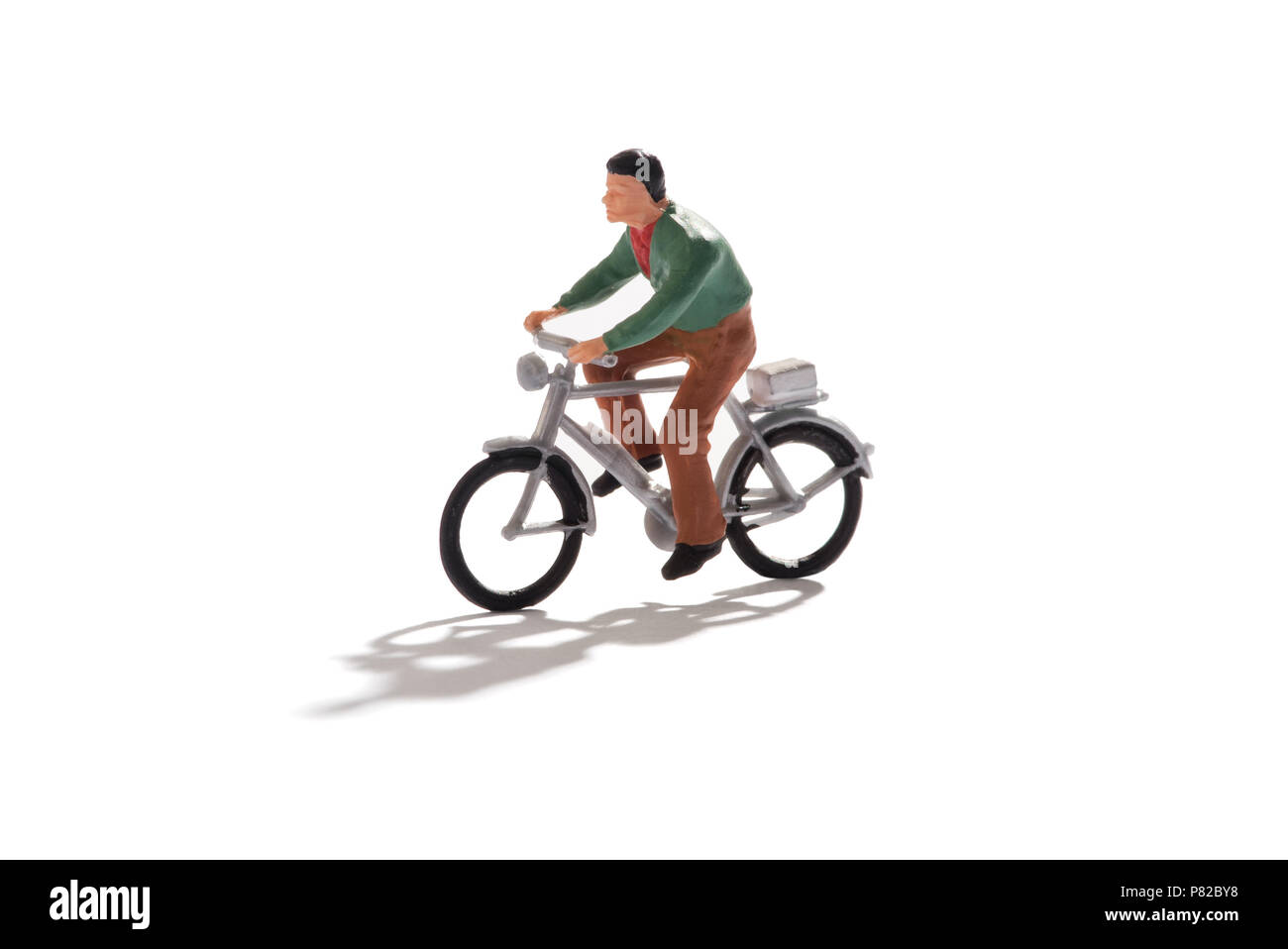 Uomo in miniatura di una bicicletta isolato su bianco con copia spazio con ombra concettuale del eco-friendly trasporti e un sano stile di vita attivo Foto Stock