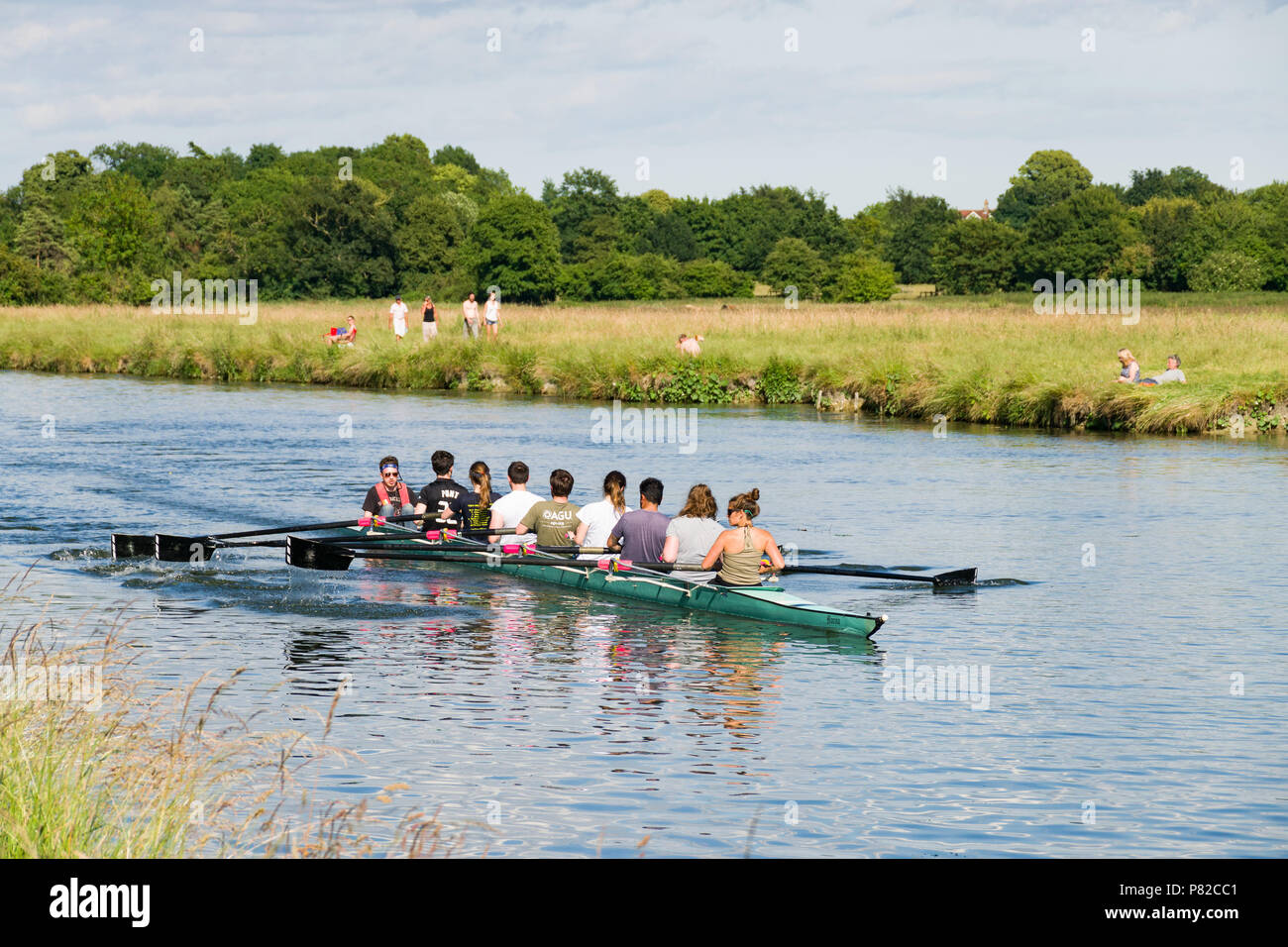 Un equipaggio di otto riga barca con uomini e donne canottaggio sul fiume Cam su una soleggiata giornata estiva, Cambridge Foto Stock