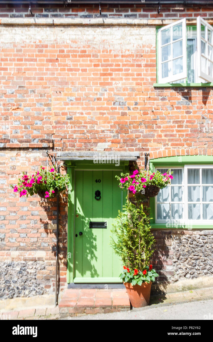 Cottage di campagna porta verde con cestini appesi e aprire la finestra, West Wycombe, Buckinghamshire, Inghilterra, Regno Unito Foto Stock