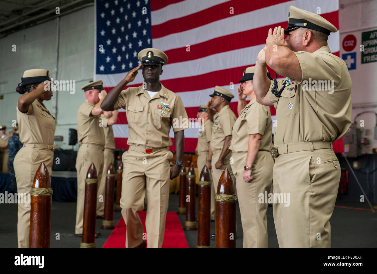 NORFOLK (sett. 16, 2016) Capo Aviation macchinista compagno del principe Agyemang, dal Ghana, Africa occidentale, è salutato dalla side boys durante un chief petty officer pinning cerimonia nella baia di hangar della portaerei USS George Washington (CVN 73). George Washington è homeported in Norfolk. Foto Stock