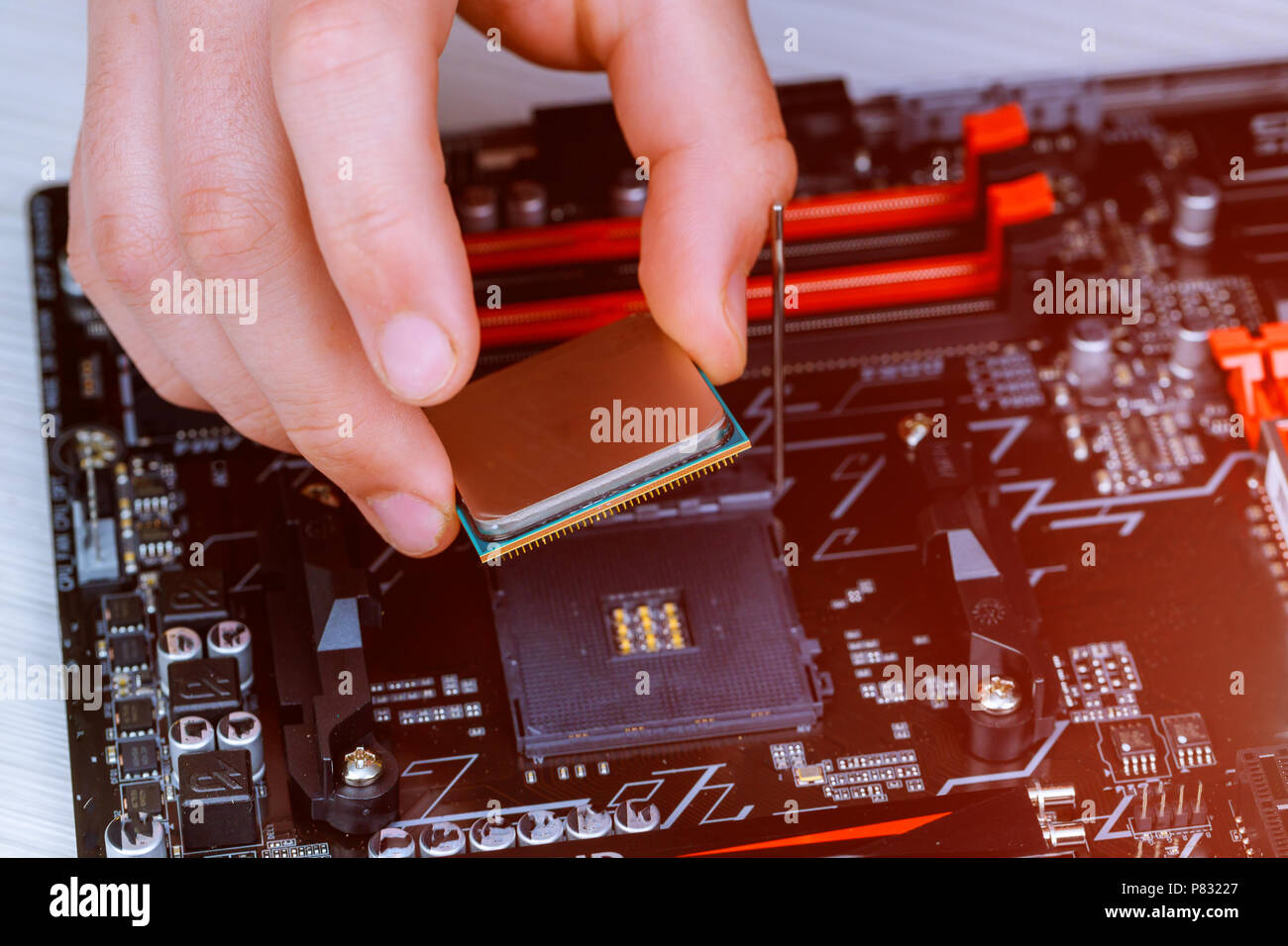 Il tecnico sta mettendo la CPU sullo zoccolo della scheda madre del computer. il concetto di hardware del calcolatore, riparazione, aggiornamento e tecnologia. Foto Stock